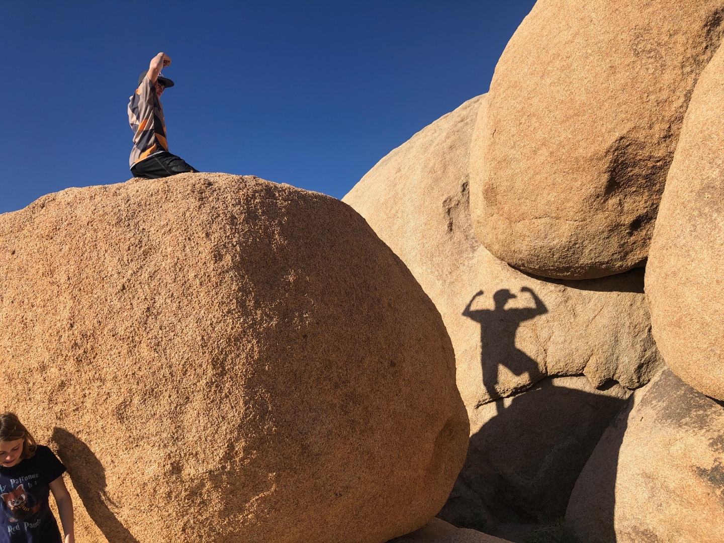 Kid flexing on a boulder in Joshua Tree